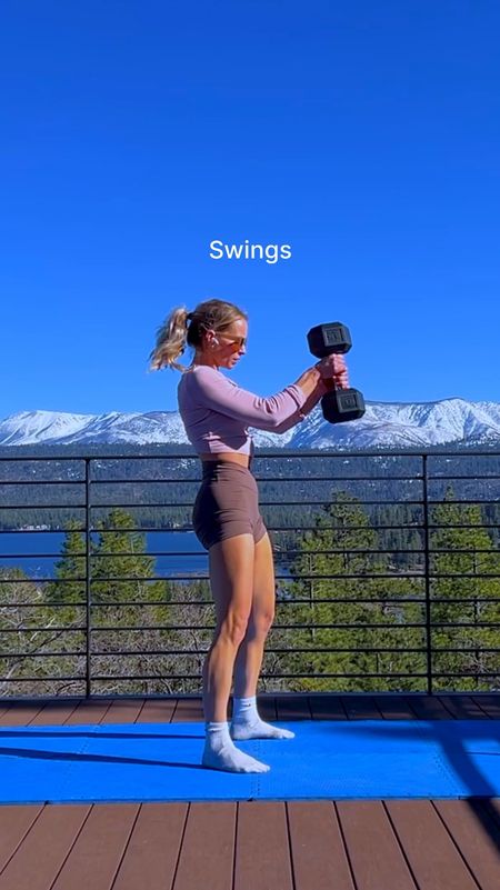 Performing double and single arm dumbbell swings in an athleisure active fit in soft summer colors: soft cool pink long sleeve, smooth ash brown gym shorts and sports bra) with white crew socks and taupe cat eye sunglasses 

#LTKStyleTip #LTKActive #LTKFitness