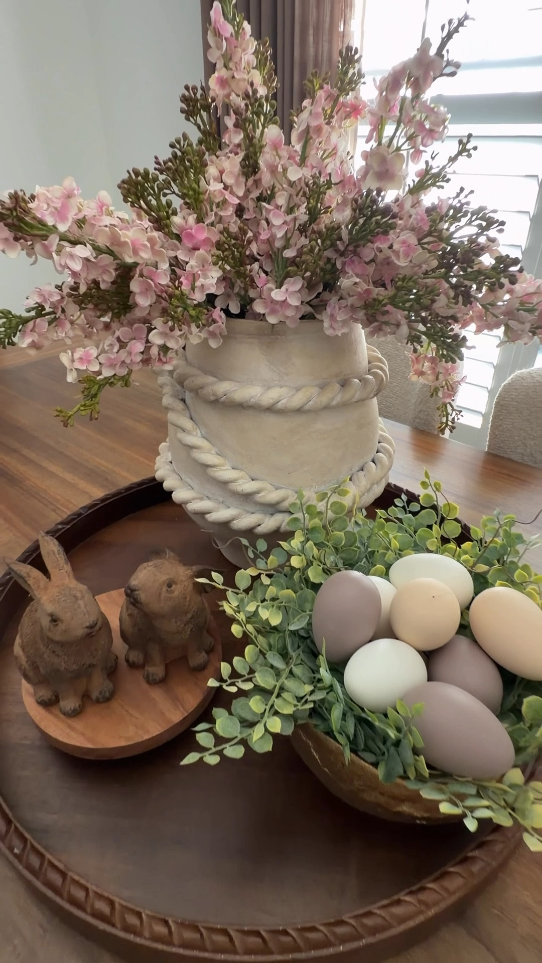 These lilac stems add the prettiest soft touch of color.

I paired them with my favorite gold bowl, a simple candle ring, neutral eggs, and the sweetest little bunnies.

Such an easy, beautiful look for your table, island, or coffee table. 🥰