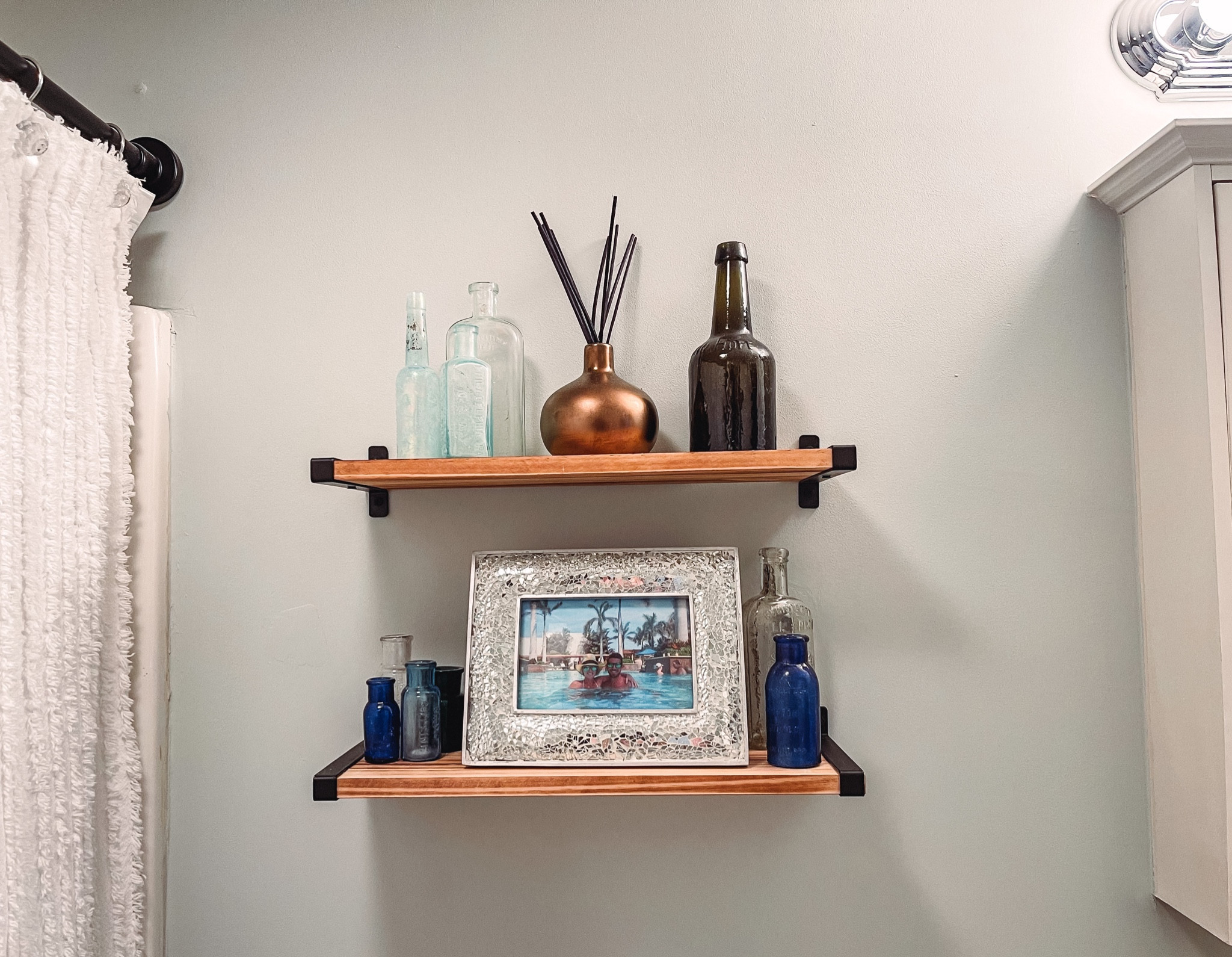 Wooden floating shelves with black hardware. Comes in several colors! Very sturdy. Decided not to use the toilet paper shelf. 
Vintage medicine bottles 
Bud vases 
Brown reed diffuser 
Rustic vintage decor 
Bathroom decor 

#LTKfindsunder50 #LTKxPrime #LTKhome