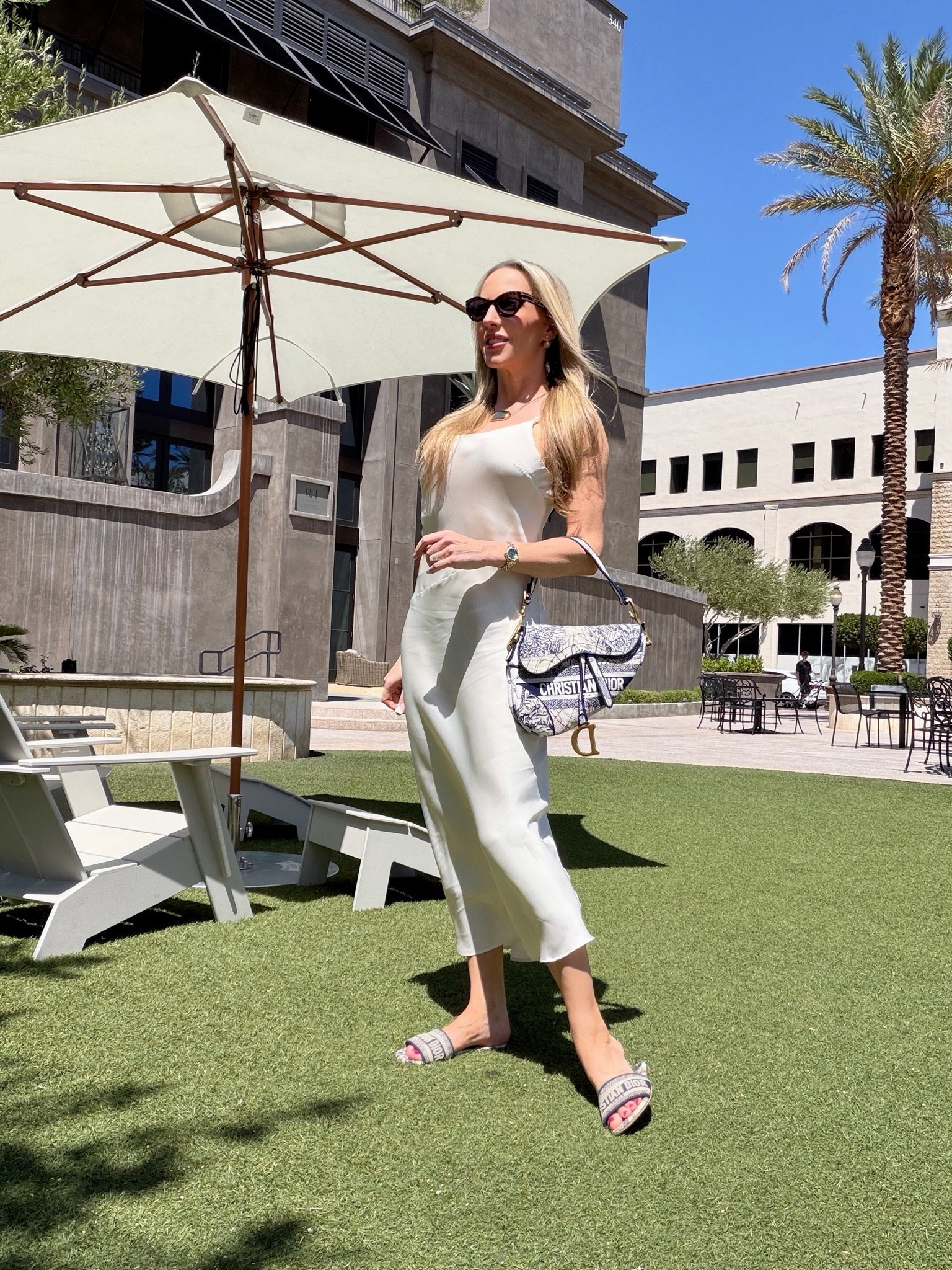 Navy and white Summer outfit: ivory white satin slip dress, black cord and gold necklace (adjustable length), Dior saddle bag borrowed from @Vivrelle Dior slides and Dior sunglasses. Use my code EVEDAWES for your 1st month Vivrelle membership for free.

#LTKootd #LTKSaleAlert #LTKPetite