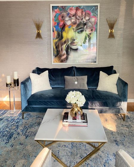 Updated this Blue velvet sofa with new throw pillows. Works perfectly with the white marble coffee table with gold base. The area rug is contemporary and fabulous !