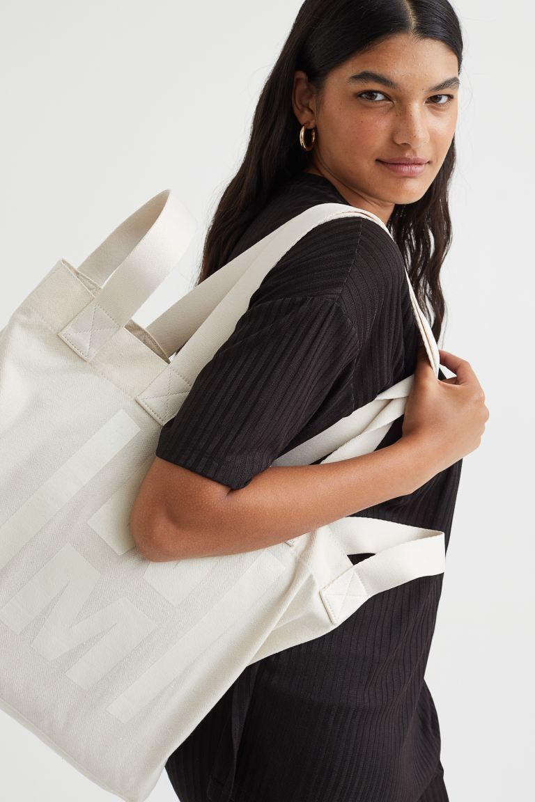 Conscious choice  Large shopper in cotton-blend canvas with a printed motif at front. Long handle... | H&M (US + CA)