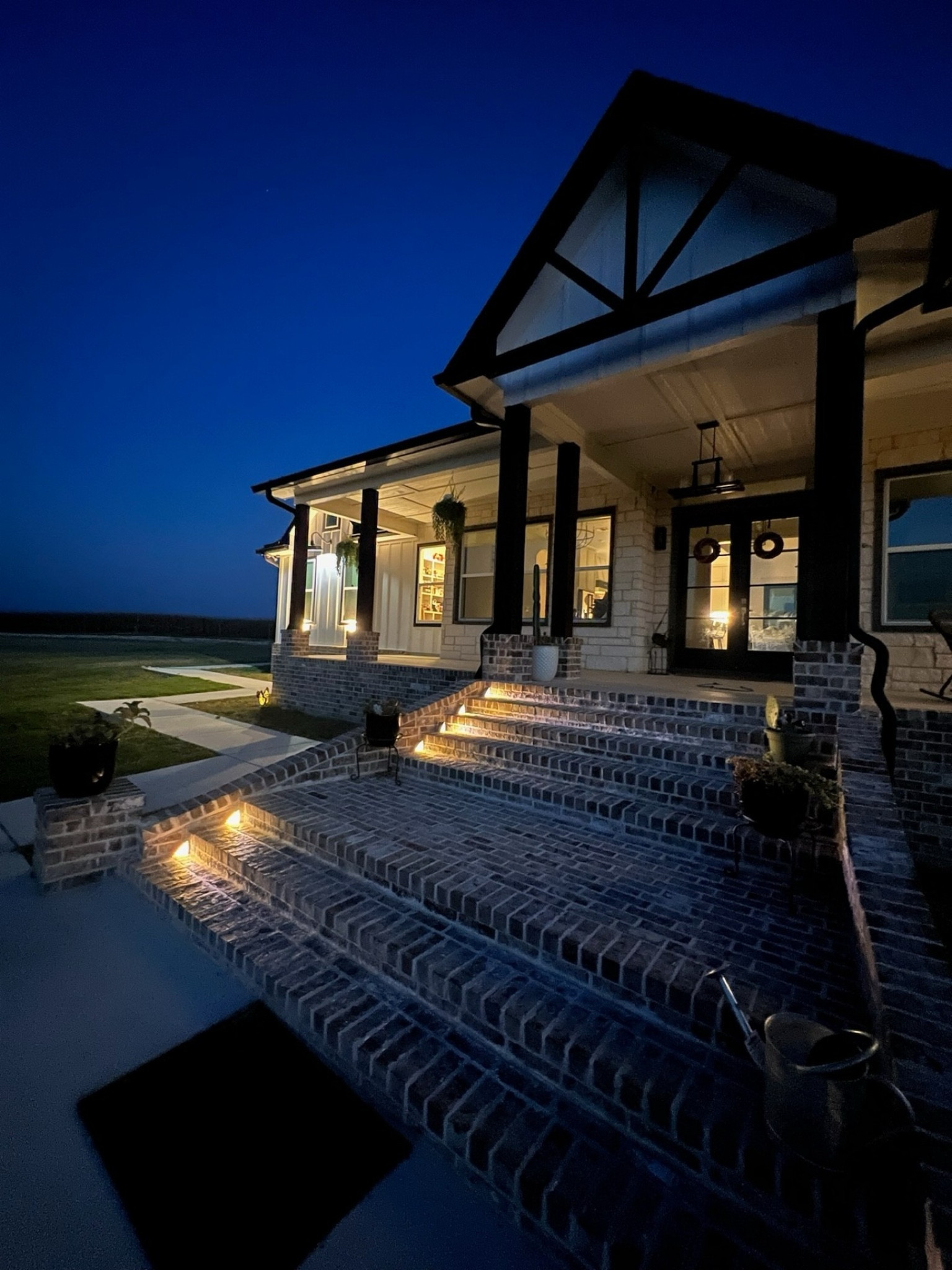 There's something so welcoming about the glow of our brick stairs at night. The subtle lighting adds the perfect touch of charm and safety, making our home feel even cozier as the sun sets.

We chose these lights to highlight the beautiful brickwork and create a warm, inviting entrance for family and friends. It’s all in the details!

If you’re curious about the lighting or want to know more about our exterior design choices, feel free to DM me for the links!
*
*
*
*
*
#OutdoorLiving #FarmhouseExterior #PatioDesign #OutdoorInspo #ExteriorGoals #ModernFarmhouseExterior #OutdoorSpaces #TexasOutdoors #BrickStairs #OutdoorLighting #CentralTexasOutdoors #PatioVibes #BackyardStyle #OutdoorGatherings #HomeExterior