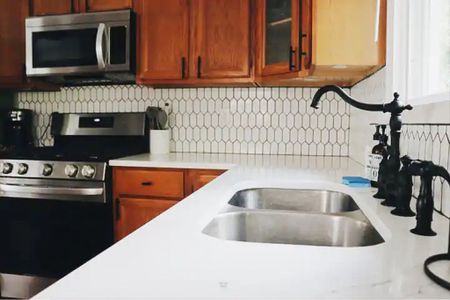 Modernize your oak kitchen cabinets with matte black hardware and faucet. Add a fun white geometric backsplash with dark grout. #kitchenbacksplash #oakcabinets #matteblackhardware #kitchenideas #diykitchenremodel

#LTKhome #LTKfindsunder50
