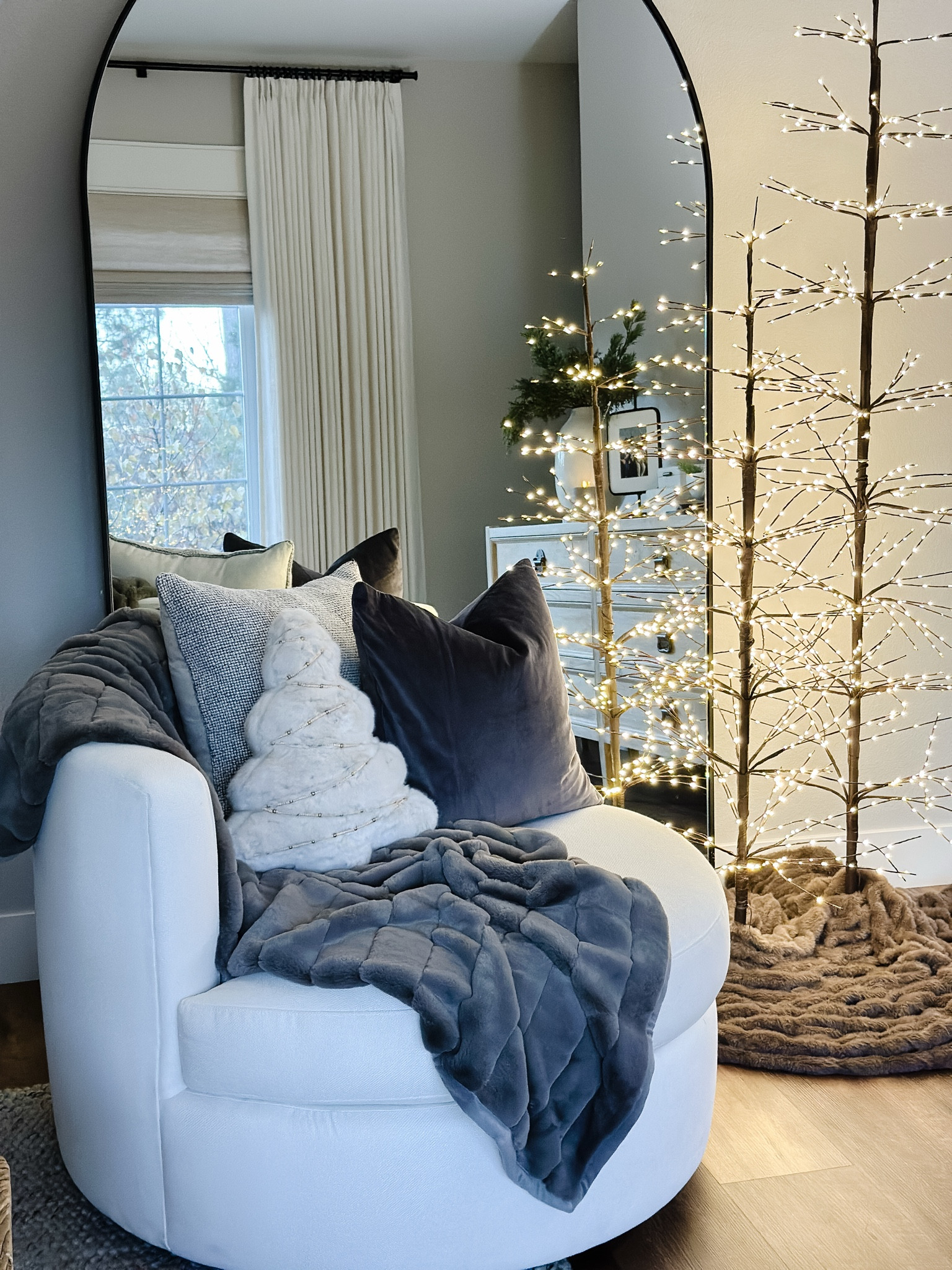 Cozy corner
Swivel chair
Twinkling lit twig trees
Oversized arched mirror
Faux fur throw

#LTKHome #LTKOver40 #LTKHoliday