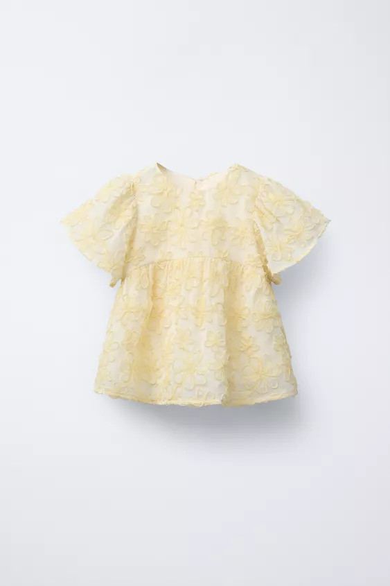 Blouse with round neck and short sleeves. Back button closure. Embroidered floral detail. | Zara US