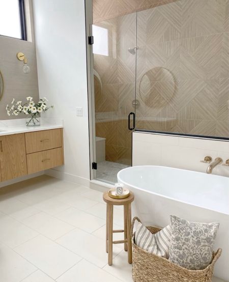 Obsessed with this simple, modern take on this master bathroom!

#bathroom #masterbathroom #bathtub #stool #basket #flowers #cabinets #accentpillow #tiles

#LTKhome #LTKstyletip #LTKU