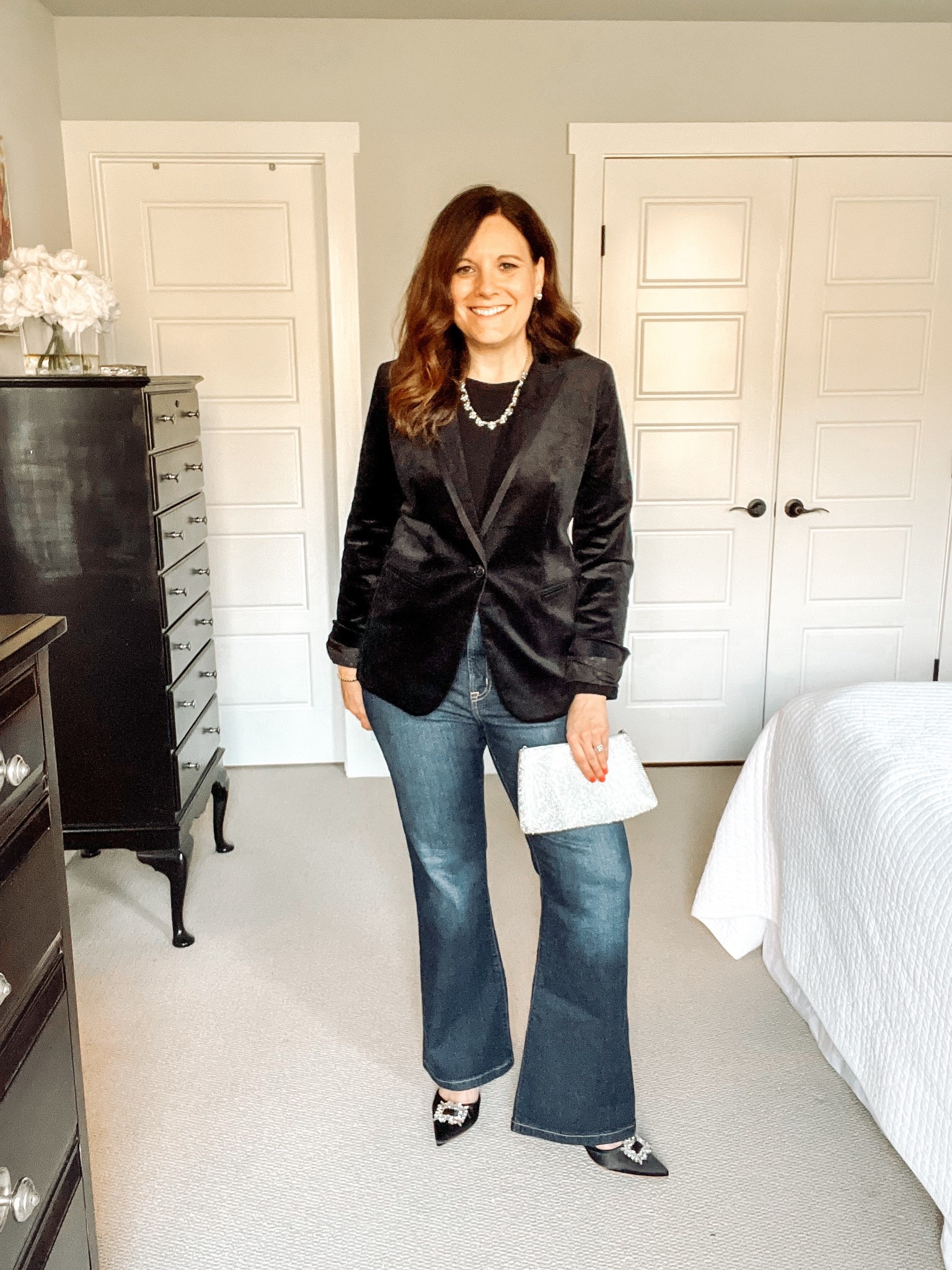 This is one of the best ways to wear your velvet blazer for special occasions. All-black with jeans is a great option and an elegant look that always works. Flare jeans with a dark wash and long length create an elevated vibe with this velvet blazer and black top. If the dress code calls for formal attire, it’s a good idea to swap out the jeans and wear plain black trousers instead. Pull the look together with a sparkly statement necklace, earrings, a rhinestone embellished bag, and ankle-wrap pumps with a rhinestone buckle. This velvet blazer is old from J.Crew Factory. Similar options are linked. These Gap flare jeans fit small. I sized up and am wearing the short length at 5’6”.

#LTKOver40 #LTKHoliday #LTKMidsize