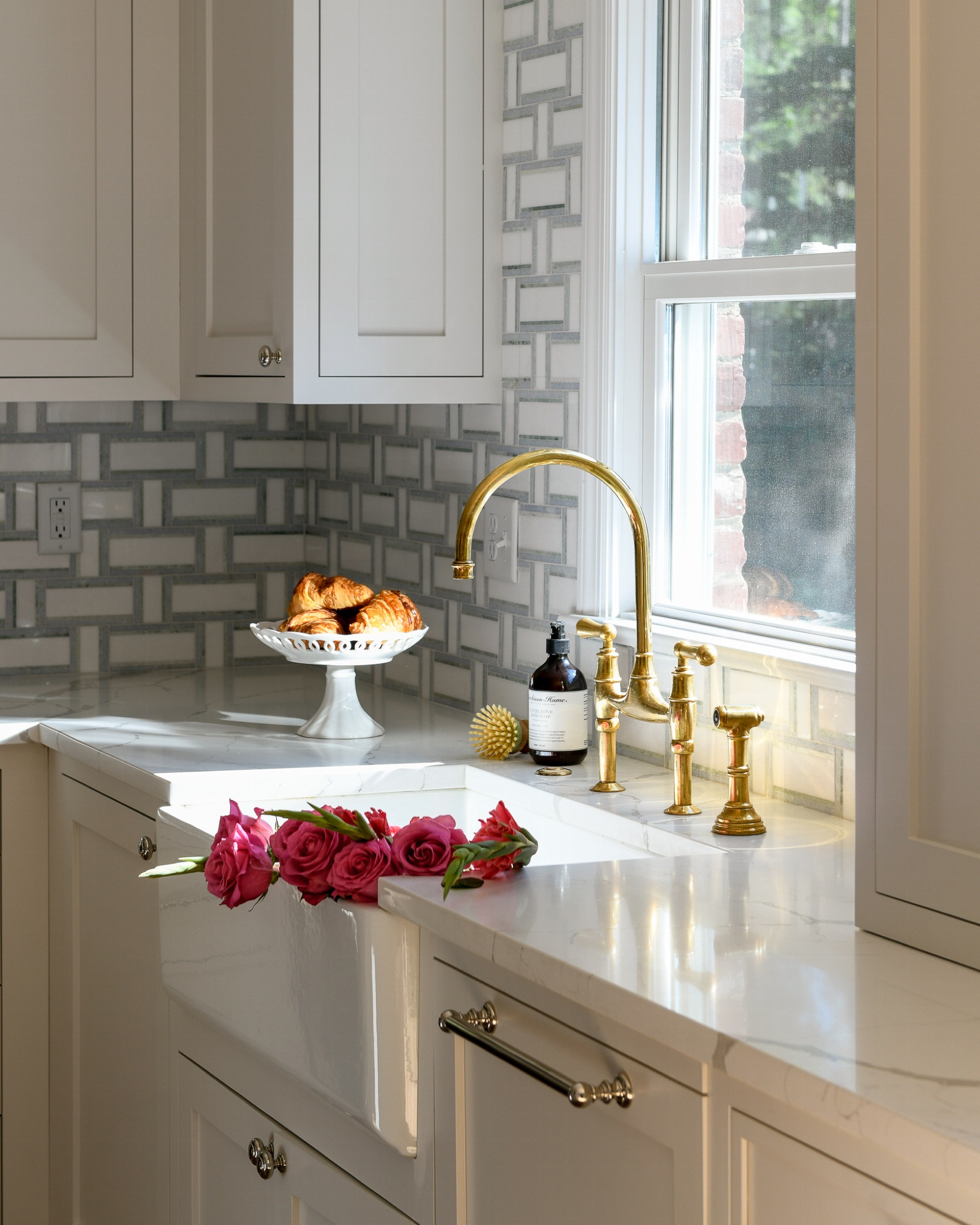 A classic traditional kitchen, with an apron front sink, Perrin and Rowe brass bridge faucet, marble backsplash  

#LTKhome #LTKFind #LTKstyletip
