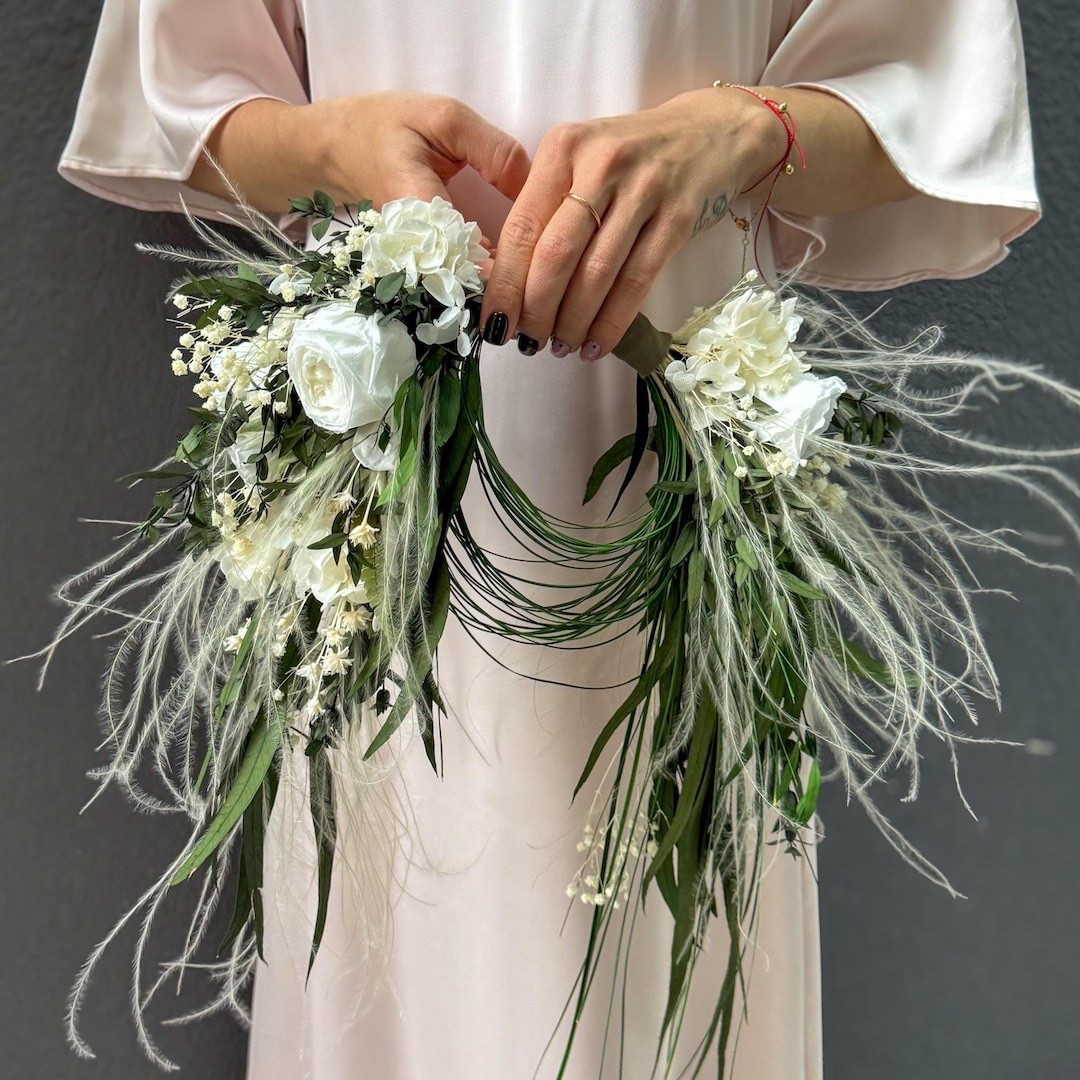 This crescent-shaped bouquet features preserved ivory roses, hydrangea, eucalyptus, fern, stakhis, and delicate baby’s breath for a soft, romantic look that feels both natural and timeless. The airy design creates beautiful movement while the preserved flowers ensure the bouquet stays stunning long after the wedding day. Perfect for brides, bridesmaids, or coordinating ceremony pieces, this handmade arrangement brings elegant texture and lasting charm to your celebration. #ltkbride #ltkhome #weddingbouquet #bridalstyle #weddinginspiration #driedflowers #preservedflowers #romanticwedding #bohowedding #weddingdetails

#LTKWedding #LTKSeasonal #LTKHome