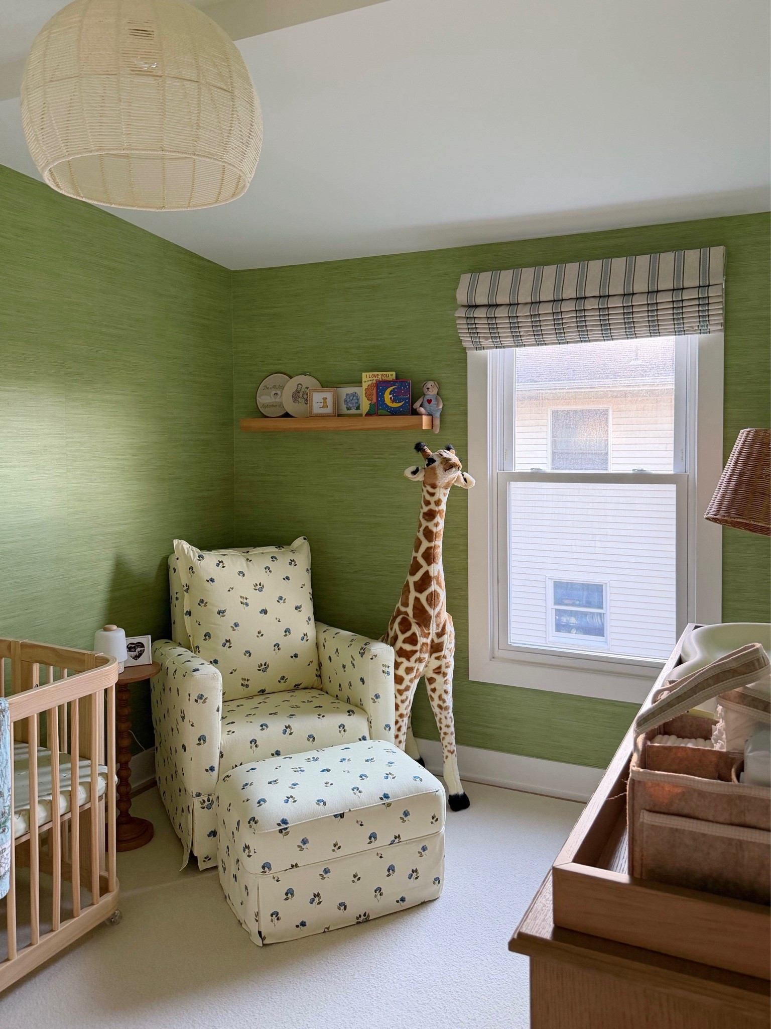 [9/21/26] details from baby Bobby’s nursery🦒✨🤍

• Roman shades are from Pepper home - Margot Fern without tassel trim included
• Nursery glider is from Nestig (The Drift Glider Recliner Nestig x Zoë Feldman) in blue mini meadow, unfortunately not linkable! We have another nursery glider in our master bedroom from @oilostudio, linking that as well! 
• Crib is from Nestig as well (The wave crib in natural wood) linking similar options! ￼
• Carpet is custom from Home Depot linking exact
• Drawer and changing table is from pottery barn (Fillmore 8-Drawer Changing Table in seadrift and natural cane) paired with Keekaroo Peanut changer
• Floor lamp is a few seasons ago from Anthropologie, linking similar! 
• Hanging lamp came with the house, but found the same (if not very similar!) on crate and barrel kids