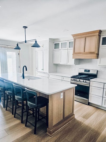A bright,  beautiful, white kitchen accented with natural oak island and hood and the perfect contrast with black lighting & barstools!

#LTKparties #LTKhome