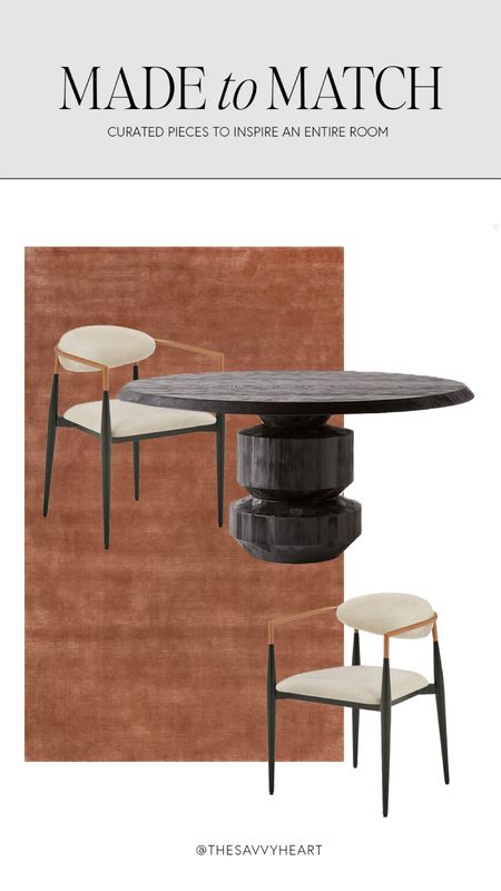 Contemporary dining room design with a sculptural, black round dining table, white, black, and gold, dining chairs with arms, burnt orange and rust, colored wool rug.