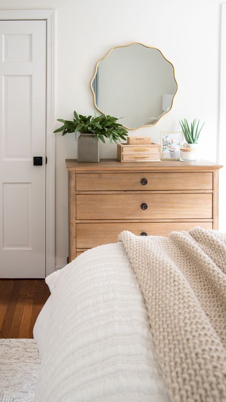 Neutral coastal style bedroom with wood dresser, artificial plants, gold scalloped mirror, throw blankets, white quilts, and more home decor items

#LTKfamily #LTKhome