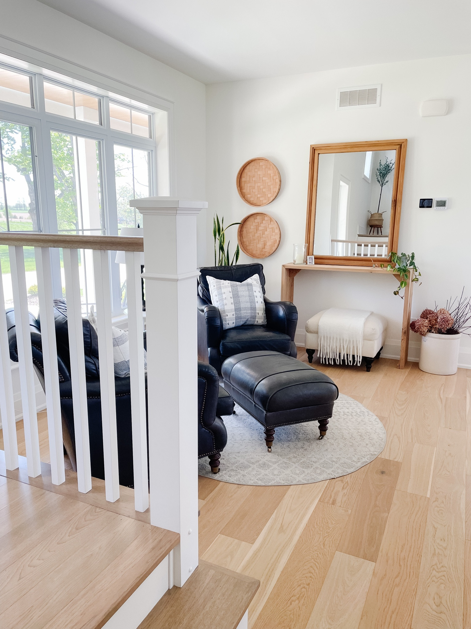 FARMHOUSE SITTING AREA 
.
I created our sitting area by adding two comfortable black leather chairs, an ottoman with some throws and some pillows — then add in a console table --and a few decor items along with a large wooden mirror!

#LTKhome #LTKFind #LTKstyletip