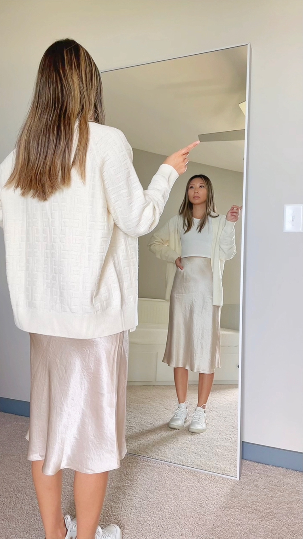 Summer to fall transitional outfit // White oversized sweater cardigan - Hermès, White cropped high neck ribbed tank top - AE, Light beige satin midi skirt - Aritzia, White sneakers - Veja // summer style, fall outfit, neutral style

#LTKstyletip #LTKSeasonal #LTKunder100