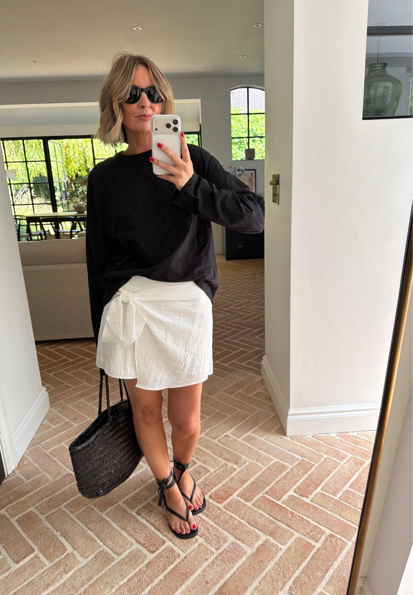white wrap skirt, tie front skort, black oversized sweater, black long sleeve top, casual weekend outfit, strappy sandals, lace up sandals, woven straw tote, black woven bag, black cat eye sunglasses, summer casual style, effortless summer style, monochrome styling, quiet luxury, elevated basics, neutral color palette, mirror selfie ootd, ltkstyletip, ltkseasonal, ltksummer, ltkfindsunder100, ltkbeauty, ltkitbag

#LTKsummer #LTKtravel #LTKeurope