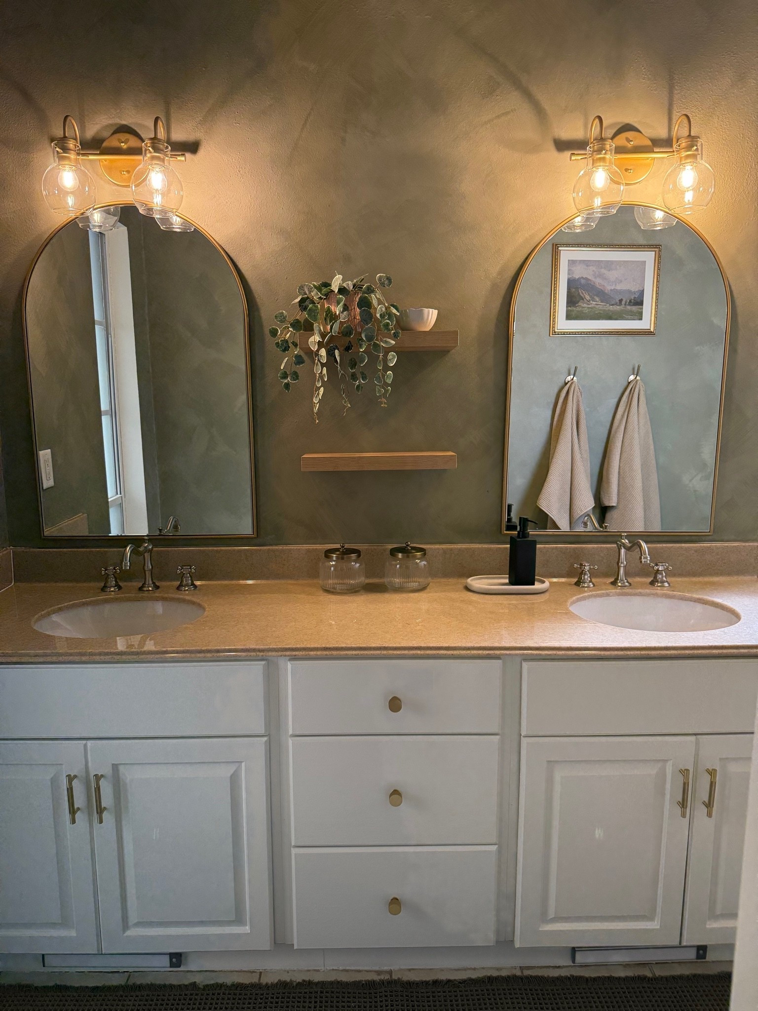 Proof that you can make an older bathroom feel completely different without replacing the vanity ✨ We worked with what we had and updated this bathroom with paint, arched brass mirrors, warm lighting, new hardware + a few simple decor pieces. I love how much character the brass and vintage-inspired details added.

#LTKHome