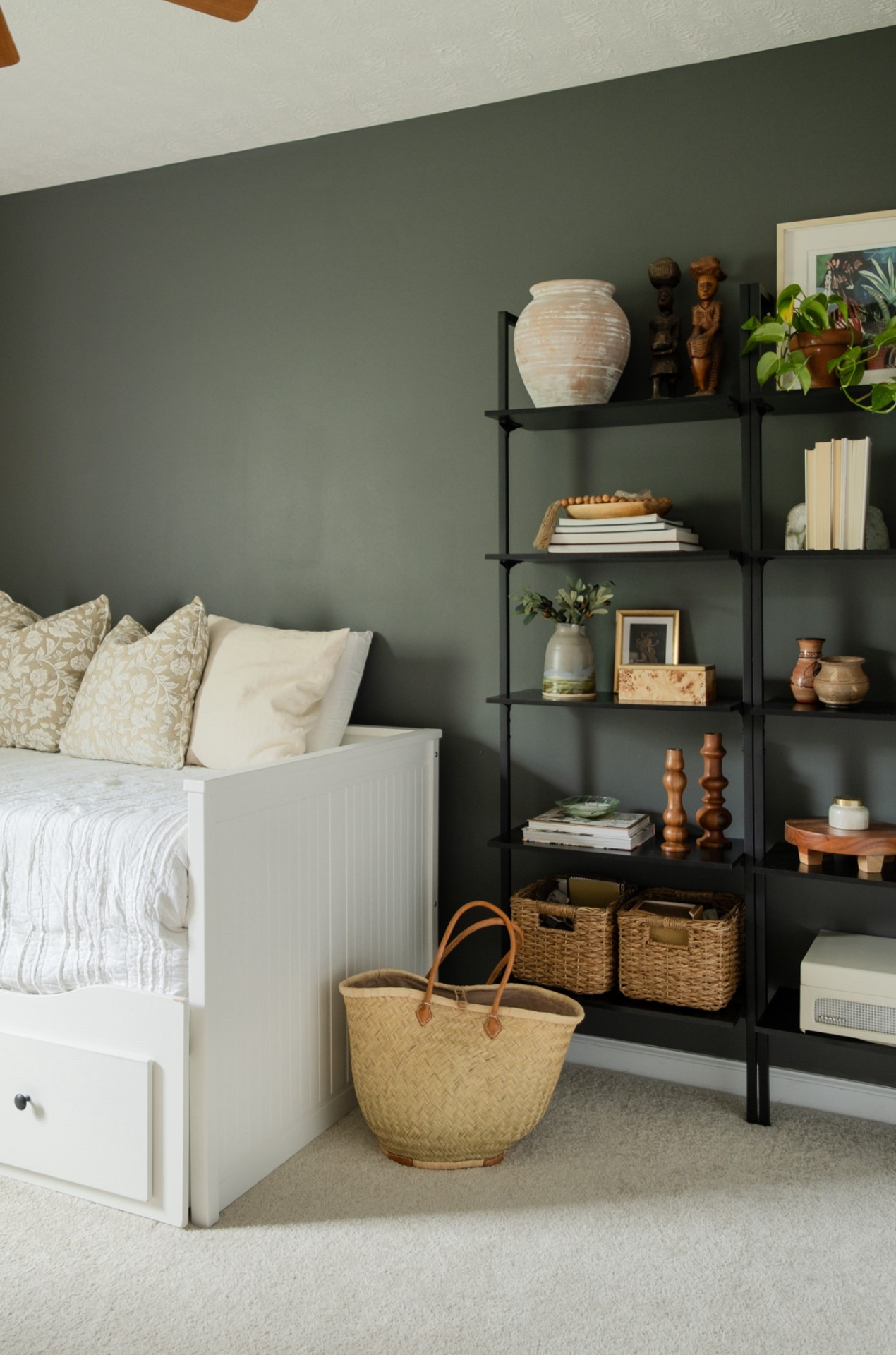 a little corner of our office/guest room. IKEA daybed for the win with wall mounted shelves to hold our trinkets from around the world.