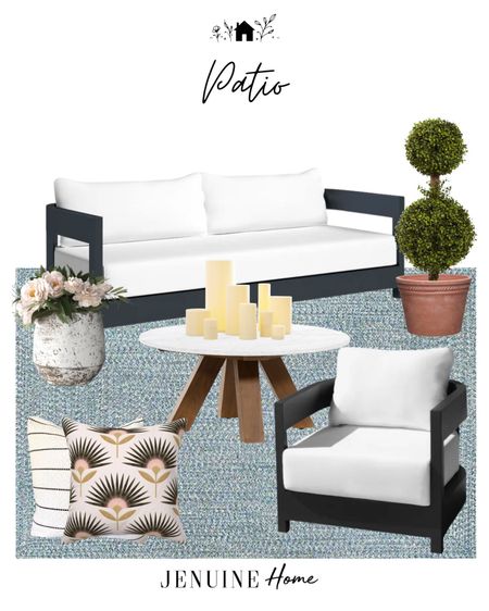 Black and white patio. Classic patio. Classic modern patio seating set. White and wood outdoor coffee table. Flameless candle decor. Faux topiary. Pottery planter pot. Black and pink outdoor throw pillow. Black and white striped throw pillow. Blue outdoor rug  