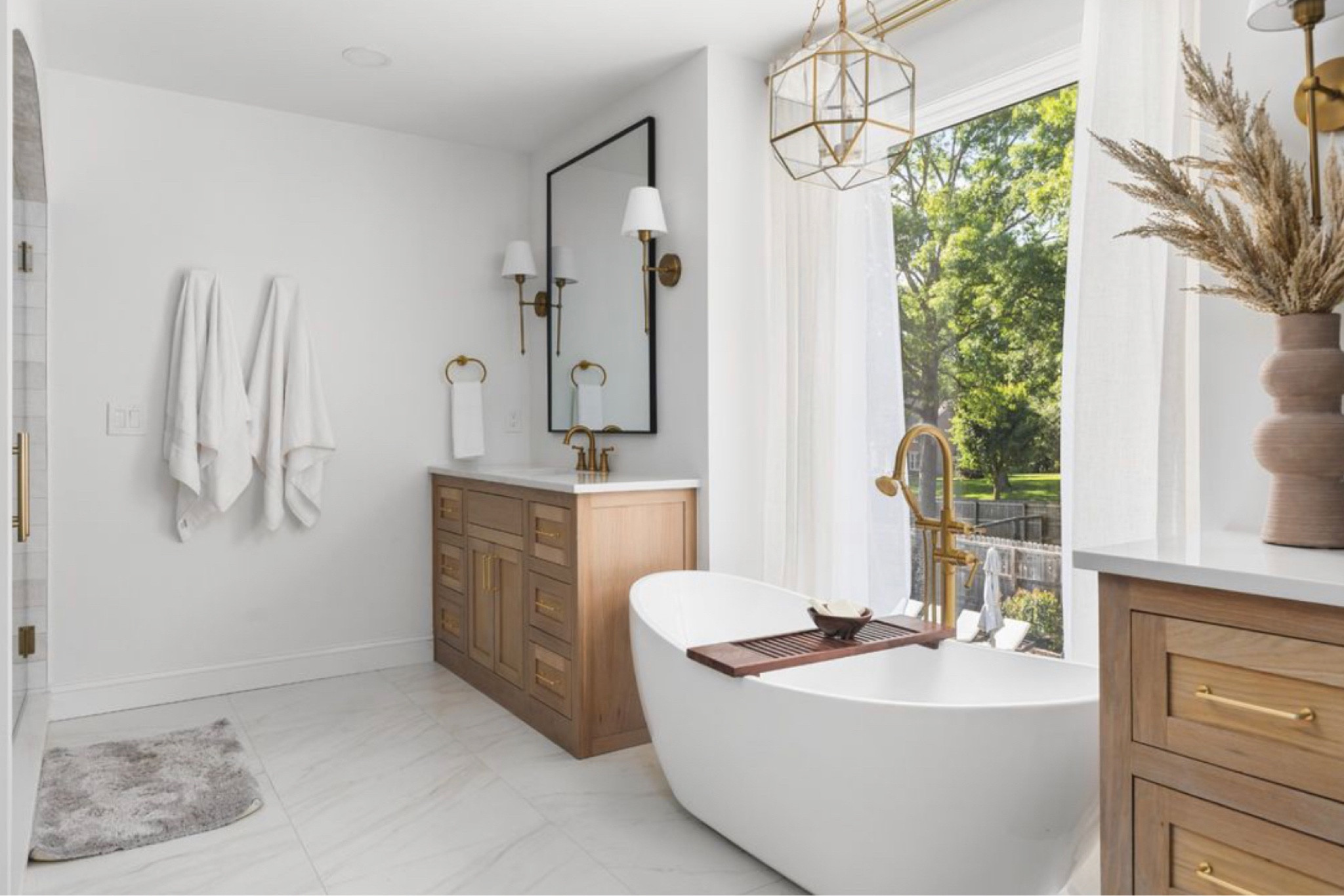 I absolutely love how our master bathroom came out. These vanities with the tub between and the large window are to die for! These are custom white oak vanities. However I linked one very similar! 

Master bathroom
Bathroom suite 
Vanity 
60” single vanity
Chandelier 
Mirror
Sconce lights 
Bath tub

#LTKHome #LTKU #LTKStyleTip