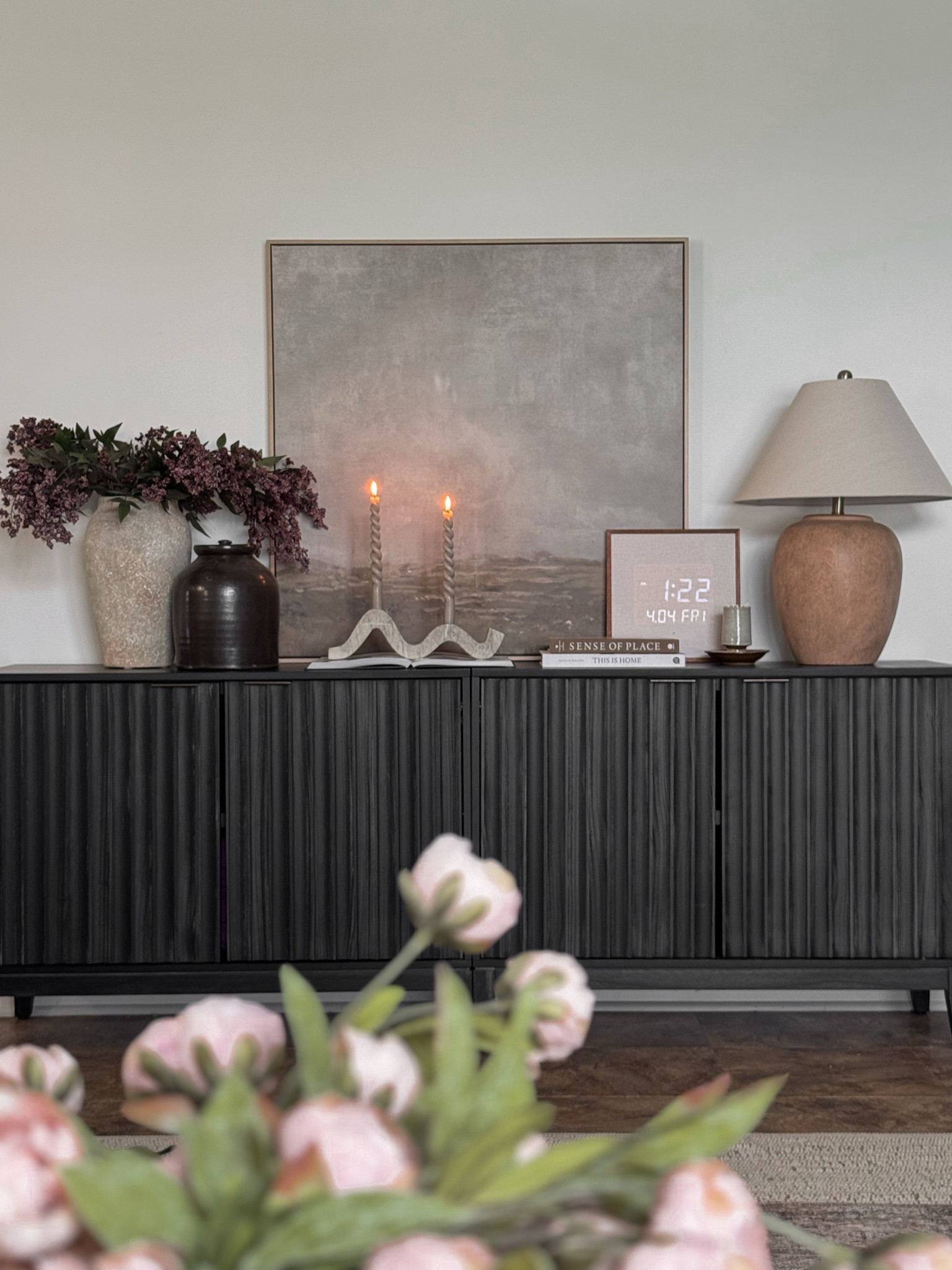 Spring decor, living room decor, table lamp, candle holder, wall art, digital clock, black sideboard, cabinet styling, sideboard styling, spring stems, vases, coffee table books

#LTKHome