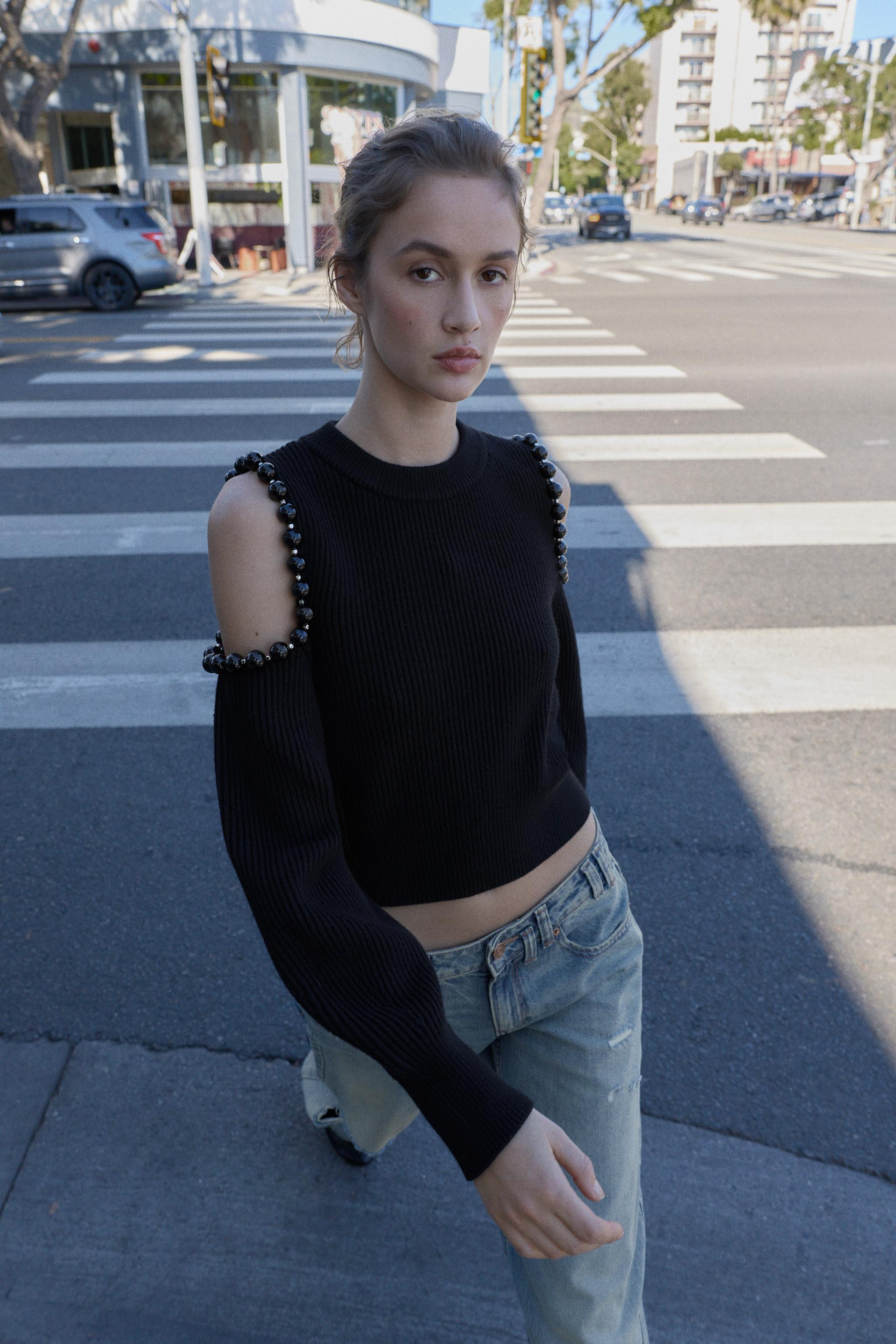 Rib knit jumper with round neck. Long cuffed sleeves with cut-outs with balls on shoulders. | Zara US