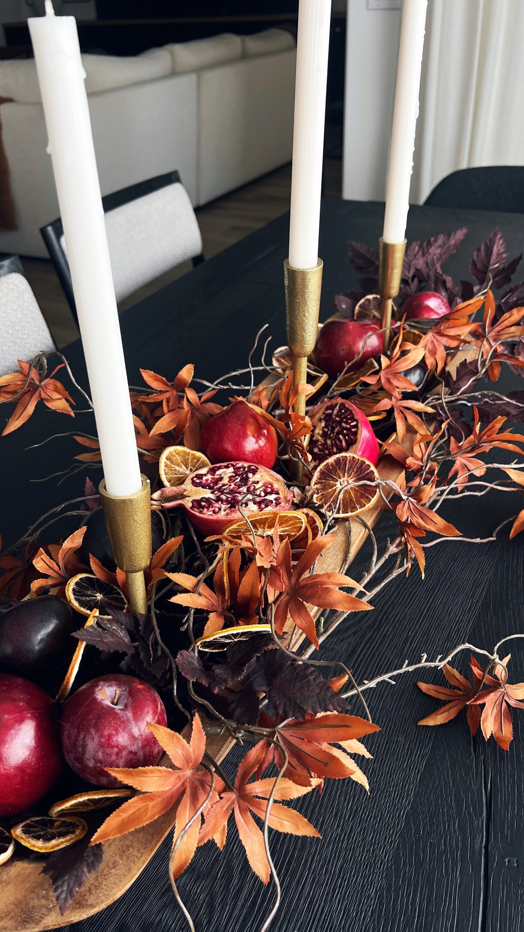 A beautiful fall table centerpiece using a dough bowl layered with plum cimicifuga stems, and Japanese maple stems plus dried fruit and fresh fruit, including pomegranates. 

#LTKSeasonal #LTKHome