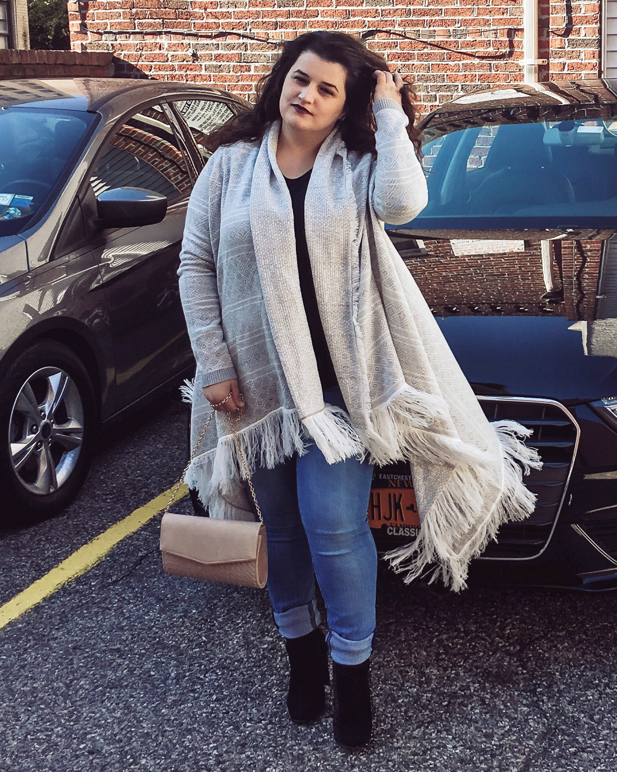 Fall fashion. Black booties. Sweater cape with fringe. Beige bag and blue denim jeans. Burgundy / dark lipstick and a black long sleeve basic top 

#LTKworkwear #LTKshoecrush #LTKSeasonal