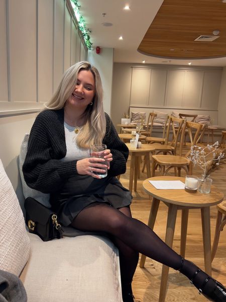 cosy sunday winter outfit with grey rib knit shrug/arm warmers, grey marl cotton vest top, charcoal grey box pleat mini skirt, black coach tabby 26 shoulder bag, black sheer tights and patent black buckle mary jane ballerina flats with a gold locket pendant 

#LTKstyletip