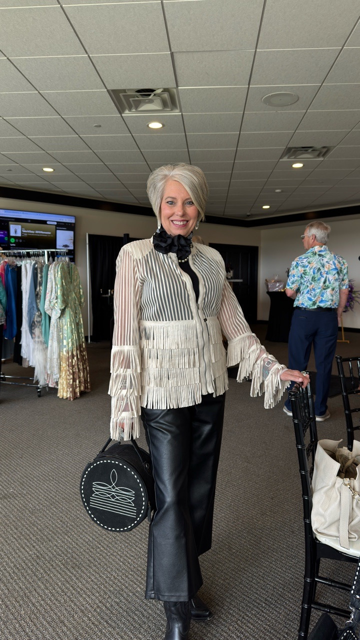 This look is proof that styling is your superpower. Take a classic base, sleek black, a little structure, then layer in personality. Fringe for movement, a statement scarf for polish, and a touch of western soul to make it yours.

It’s not about having more. It’s about styling what you already have with intention. When you do that, you don’t just get dressed, you show up.

Add the scarf. Try the fringe. Wear the boot. Carry the bag. Walk in like you’re meant to be seen. 

The best accessory is the way you wear your clothes. So smile, shine, and own your look! 

Fringe Jacket by @theclassactboutique 
Cantina Bag by @americandarlingofficial 
Obsidian Casanova Boots by @ariatfortworth 

#fashionover50 #westernfashion #westernchic #westernstyle #elevatedstyle