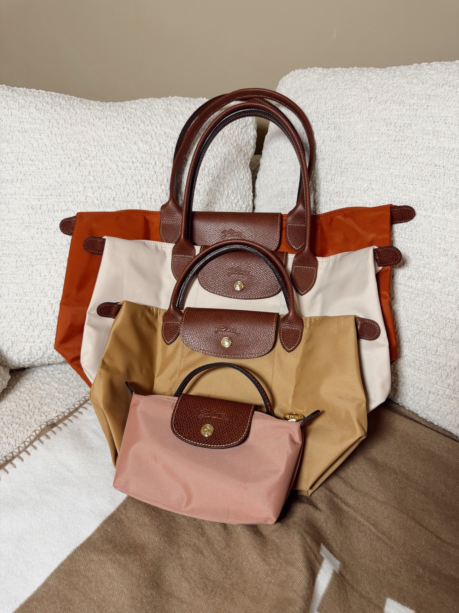 These are my ladies 👜

Longchamp large Le Pliage tote in the color brick
Medium Le Pliage in the color paper
Small in the color fawn
Mini pouch in the color pink tea 