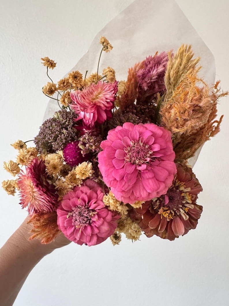 Sweet, charming, and full of natural beauty, this pink dried zinnia bouquet is perfect for bud vases, gifting, weddings, bridesmaid proposals, birthdays, and everyday décor. Featuring soft pinks, greens, and whites, each preserved wildflower bundle is uniquely crafted and wrapped in tissue paper with twine for a thoughtful finishing touch. A lovely keepsake bloom arrangement made to brighten any space. #LTKHome #LTKWedding #DriedFlowers #ZinniaBouquet #BudVaseDecor #BridesmaidGifts #EtsyFinds #FloralDecor #GiftIdeas #HomeStyling

#LTKSeasonal #LTKWedding #LTKHome