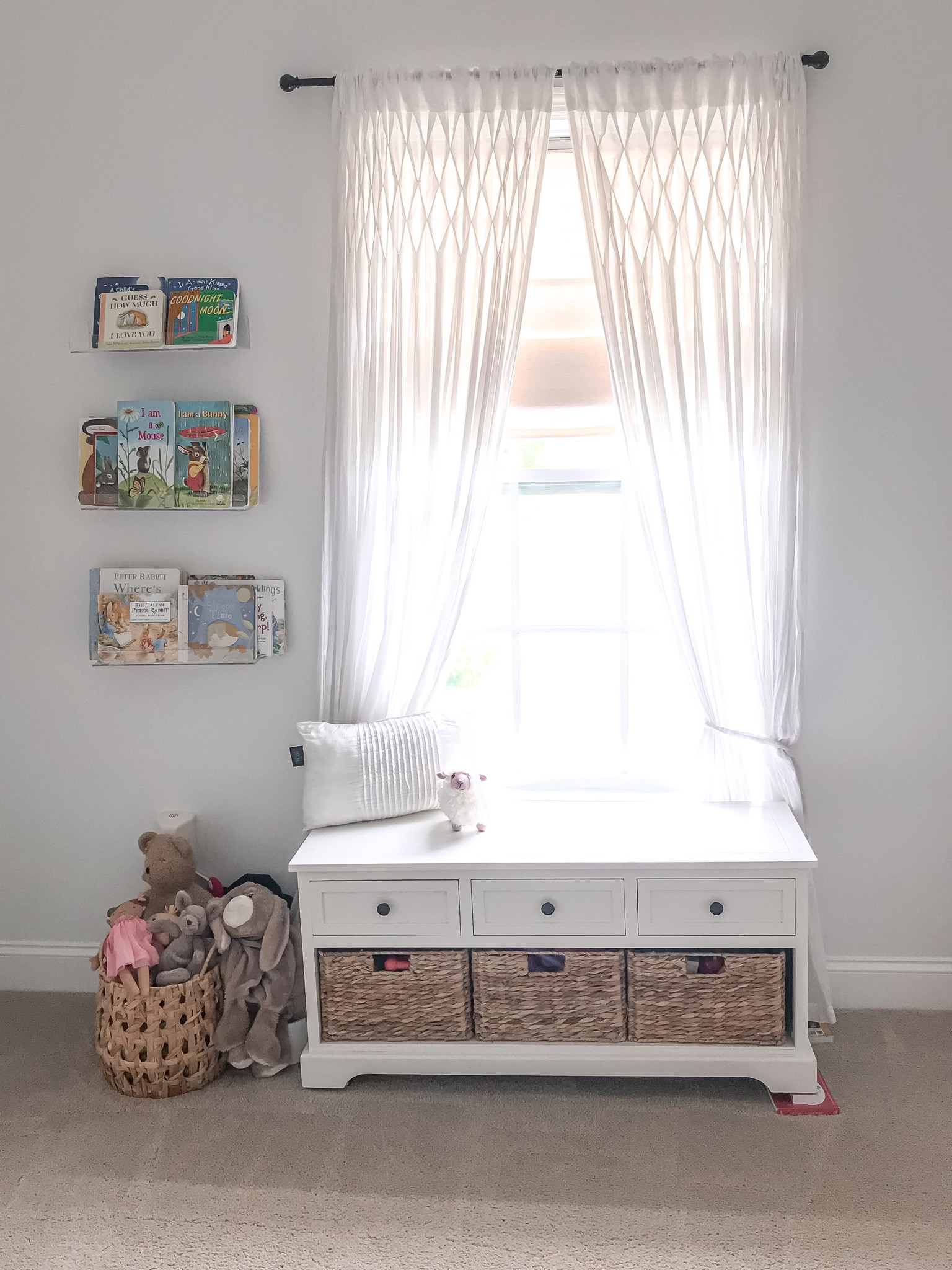 Nursery furniture and decor. . Storage and functionality is the main reason for this storage bench under the window. It’s incredible how much of El’s toys we’ve been able to store in this thing and there’s still room for some more. The wicker baskets add to the earth tones in the room and the floor basket we use for her stuffies. Since the room is small these transparent floating shelves have been perfect for her books. We interchange the books depending on the season/holiday. It comes in a pack of 4 shelves. We used three here and the fourth one is used on a different wall for her monitor. 
The window curtains came from another room in the house and are old and the shade couldn’t be linked. 
#babygirlnursery #neutralnursery #minimalistnursery #nursery #earthtonesnursery #storagebench #nurserystorage

#LTKbaby #LTKhome #LTKfamily