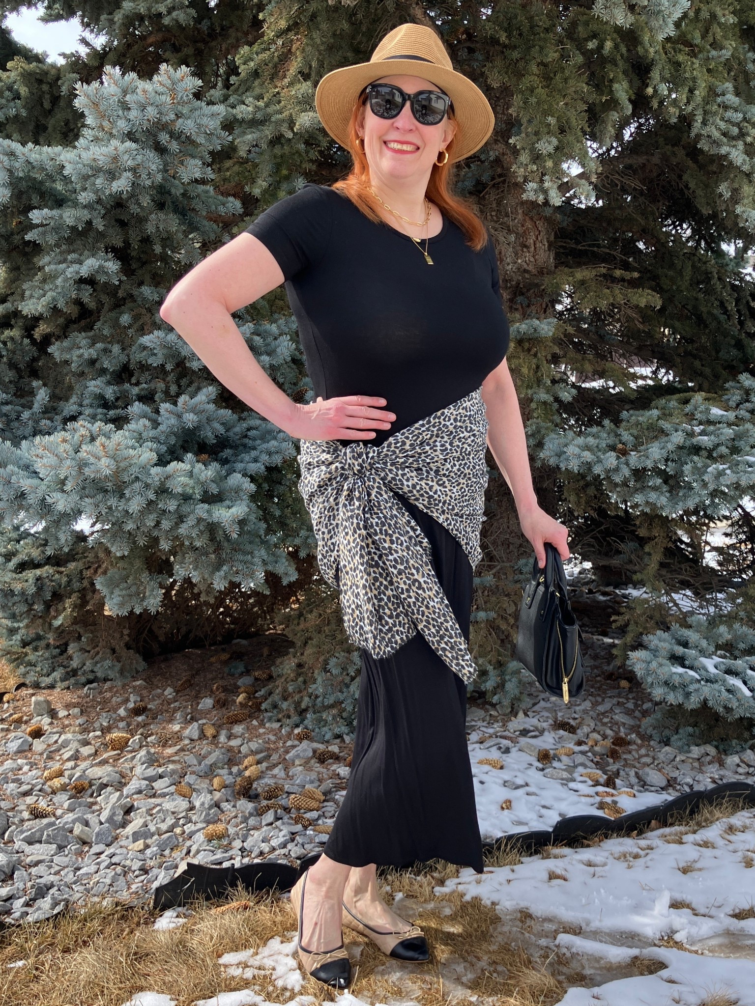 I feel like an uptown girl in this simple but chic look. I took a basic black dress and added some pizazz by tying my leopard scarf around the waist. Then I added cool sunnies, a hat, a black bag, and cute capped toe shoes. I think the tan in the shoes plays nicely with the tan straw hat. I’m looking springy despite the snow! Canadians click on the first links to shop, and Americans click on the second links to shop. If there’s only one link then you can shop it in your own country. And remember, trendy doesn’t have to be expensive! Bye!

#LTKOver40 #LTKootd #LTKMidsize
