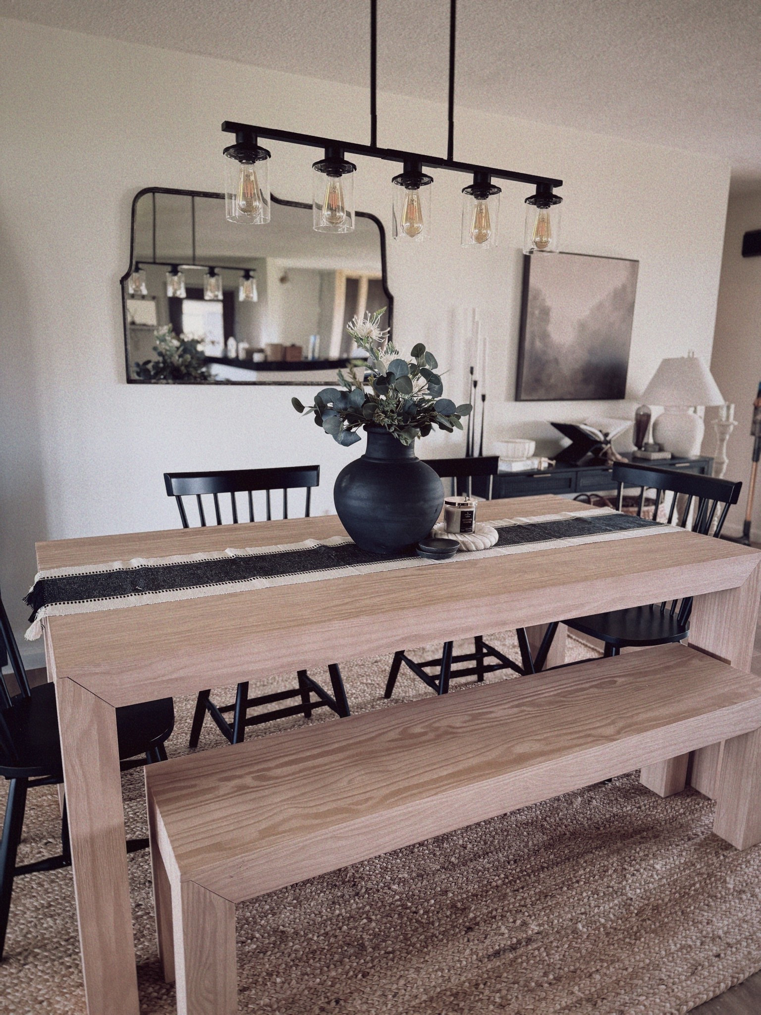 Dining room details I’m loving 🖤

This natural wood table paired with black accents and layered textures creates the perfect modern-meets-cozy vibe. The matte black vase + faux stems are such an easy way to elevate a simple centerpiece.

Everything you see — the table, bench, runner, chairs, vase, and more — is linked 

#LTKhome #diningroomdecor #modernneutral #LTKstyling #homedetails #neutralhome #blackvase #kitcheninspo #LTKfinds #organicmodern #cozyminimalism