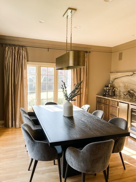 Modern vintage dining room. Sophisticated dining room design with velvet chairs, black dining table, large modern chandelier and wet bar. 

#LTKFind #LTKhome #LTKfamily