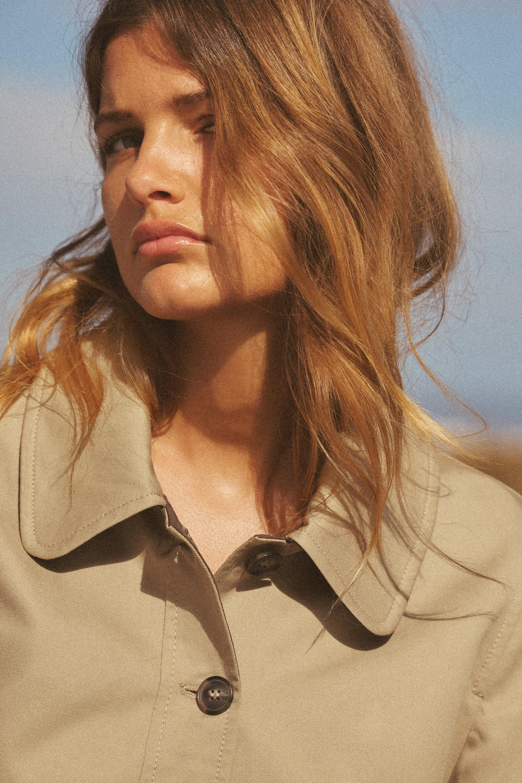 Short trench coat with lapel collar and long sleeves. Welt pockets at front. Interior lining. Fro... | Zara US