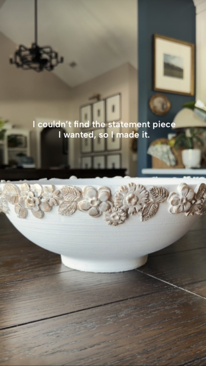 I couldn’t find the statement piece I wanted, so I made it. 🤍

Here’s how I created this vintage-modern bowl:

• Started with a bowl that had a rough texture for better adhesion
• Rolled out air-dry clay with a dough roller
• Used a cookie cutter molding set to create flowers and leaves in batches
• Used the tip of a knife to add a little more definition to the leaves
• Added a thin layer of clay around the rim of the bowl
• Used water as my “glue” to attach each flower and leaf
• Worked in small sections until the entire edge was covered
• Let it dry overnight

For the finish:

• Mixed paint and water in a 50/50 ratio
• Painted the entire bowl and let it dry
• Used a small brush to add a light brown wash to the flower and leaf details
• Applied Rub ’n Buff in brass to highlight the raised edges
• Finished with a matte spray sealer

Note: This bowl is intended as a decorative piece only and is not food safe.

One bowl, some clay, and a little creativity later… my new favorite statement piece.

#diyhomedecor #airdryclay #homedecor #CozyHome #diydecor