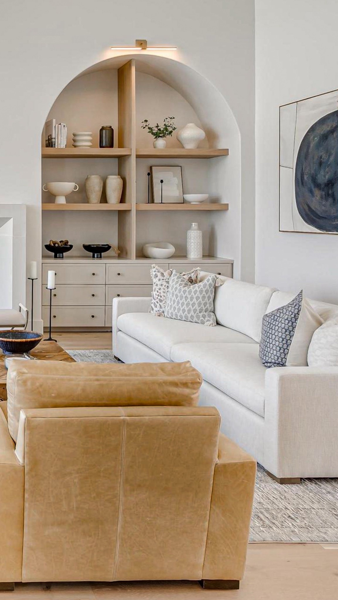 Luxury living room designed with oversized arched built ins, large vases and decor to fill these above average sized shelves. 
