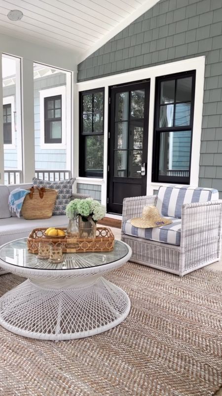 Our coastal beach house screened in porch is filled with family friendly wicker patio furniture. The cushions are also family friendly in coastal blue and white stripes.  A round wicker coffee table and jute rug both give nice texture to the space while keeping it casual! Coastal decor, serena and lily, coastal beach house, beachhouse furniture, wicker furniture, jute metallic rug, family friendly furniture 

#LTKhome