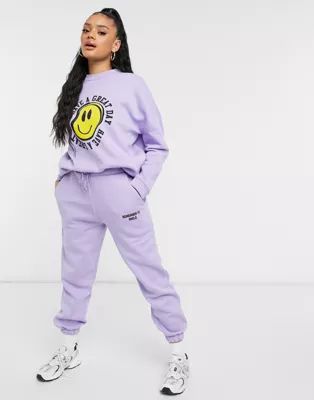 ASOS DESIGN Hourglass tracksuit oversized sweat / oversized jogger with happy face graphic in lil... | ASOS (Global)