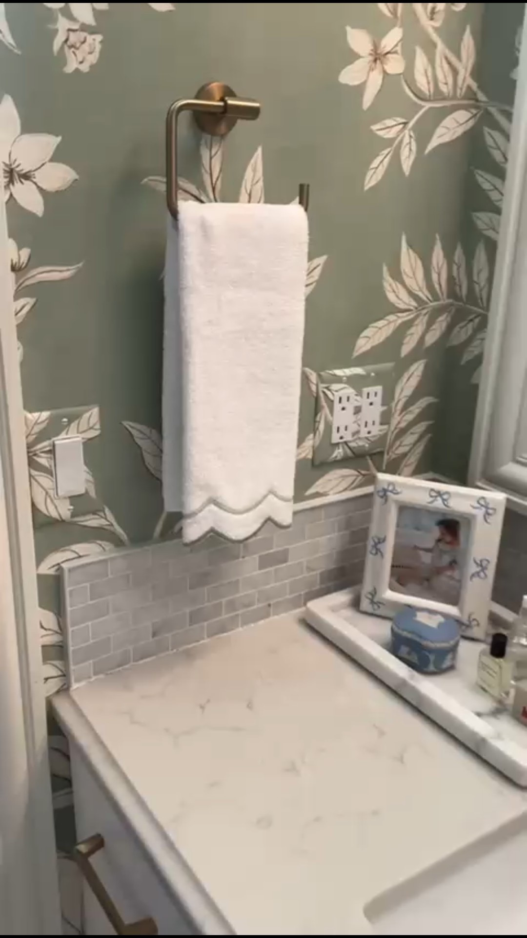 A timeless bathroom setup featuring green floral wallpaper, warm brass towel hardware, a marble vanity countertop, and soft neutral accents.

#LTKHome