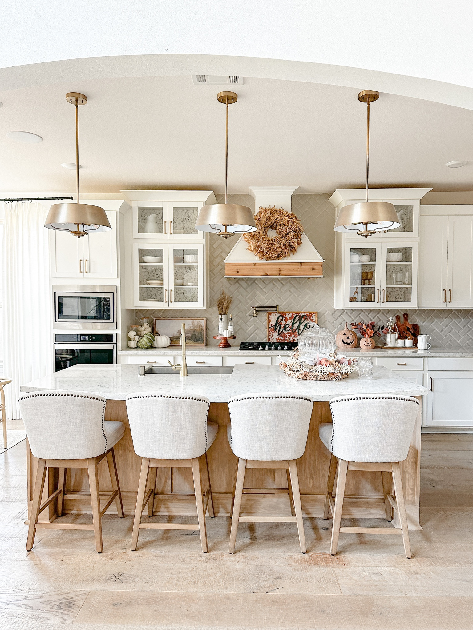 My Falloween kitchen!! Full of classic fall colors! Loving my beautiful corn shuck wreath!! 
Barstools, linen bar stools, neutral bar stools, champagne bronze pendant lights, fall wall art, pumpkins, pumpkin drink dispenser, pumpkin mugs, fall colors, Halloween, faux florals, fall florals, neutral florals, white kitchens #LTKFind 

#LTKSeasonal #LTKhome