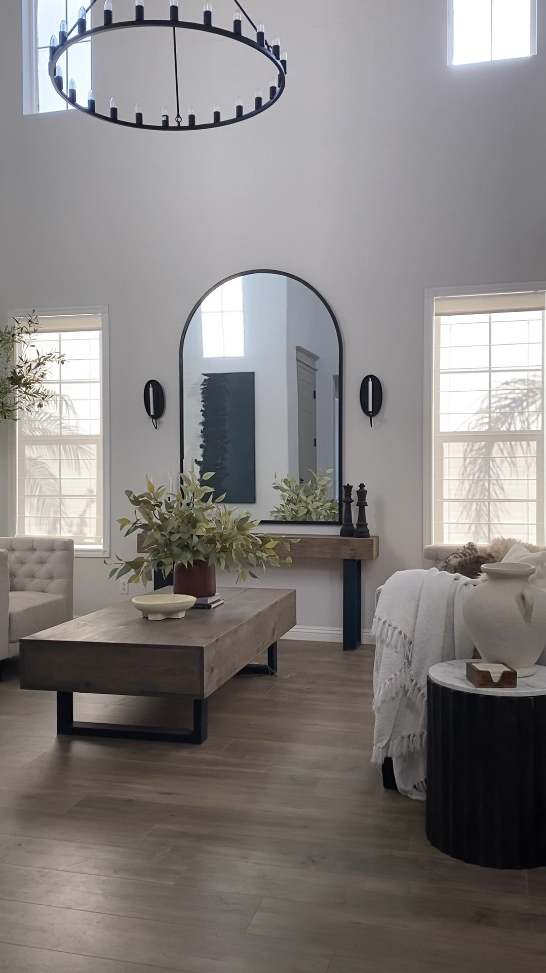 Roman shades. Full length mirror. Arch mirror. Arched mirror. Huge mirror. Ivory sofa. Tufted sofa. Wagon wheel chandelier. Huge chandelier. Throw blanket. Tall olive tree. Living room decor. Neutral home decor. #wayfair

#LTKhome