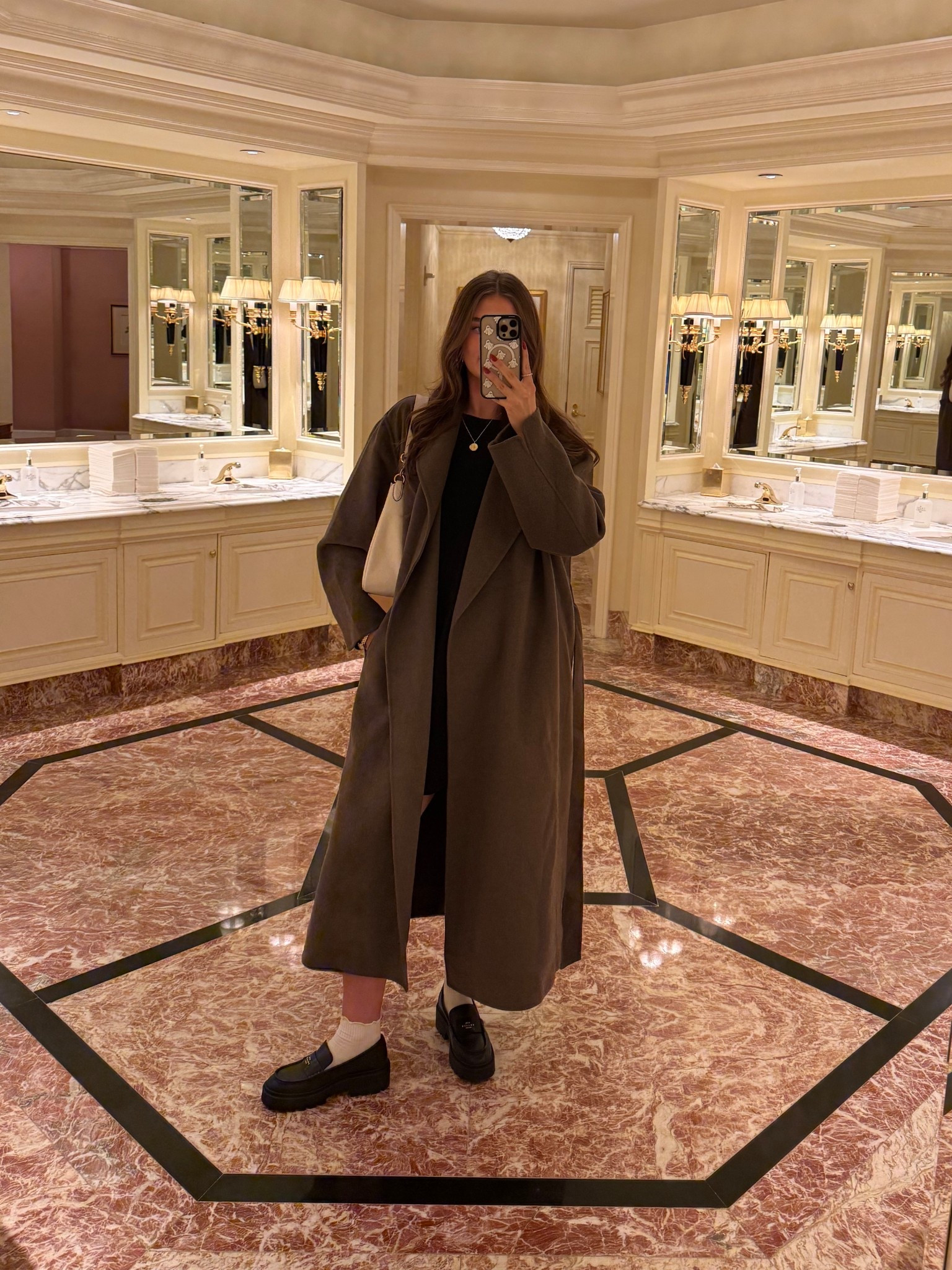 Brown trench coat, black coach loafers, white coach bag, black mini dress 