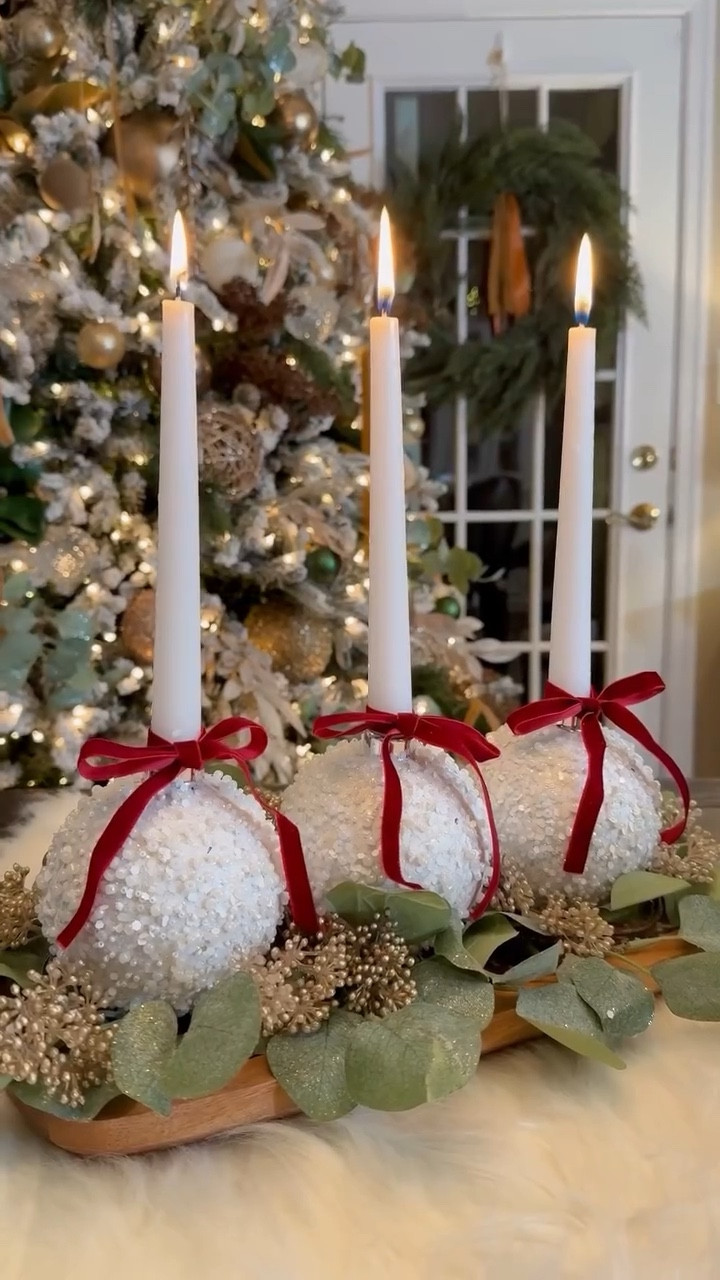 DIY Ornament Taper Centerpiece ✨elevate your holiday decor with this easy and elegant arrangement! I used some extra 4-inch ornaments I had around s the house for that perfect fit—just ensure the opening is large enough to hold your taper candles. For balance and to avoid top heaviness, I opted for shorter tapers and secured everything onto my tray with Command double-sided hook and loop tape. Here are some extra tips for added security:

Start by choosing a sturdy tray to support the weight of your ornaments and candles, and arrange the ornaments evenly for balance. Layer duct tape under the ornaments with hook and loop strips for extra security, or use hot glue for a more permanent hold. Fill the base with greens for a lush look, which will also hide the adhesive tape and keep everything in place. Tuck some berry bunches under the ornaments to ensure they stay level if they wobble, and finish it off by tying a velvet ribbon around the base of the taper at the mouth of the ornament. Enjoy your beautiful centerpiece! 🎄✨

#LTKFindsUnder50 #LTKHoliday #LTKGiftGuide