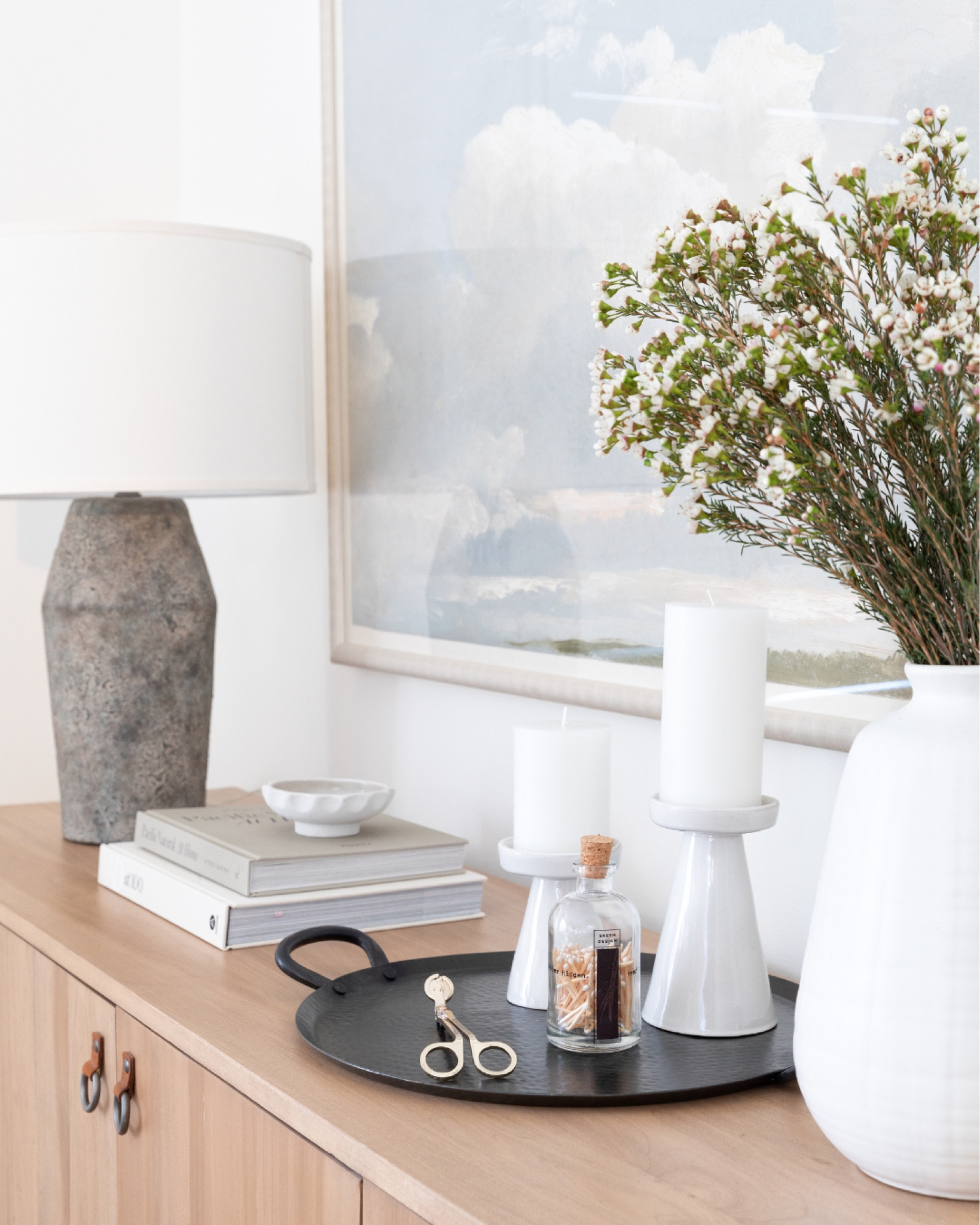 Transitional sideboard styling. Scandinavian design.

Textured table lamp. White oak sideboard. Coffee table books. White vase. Greenery. Candles and matchsticks  

#LTKunder50 #LTKhome #LTKstyletip