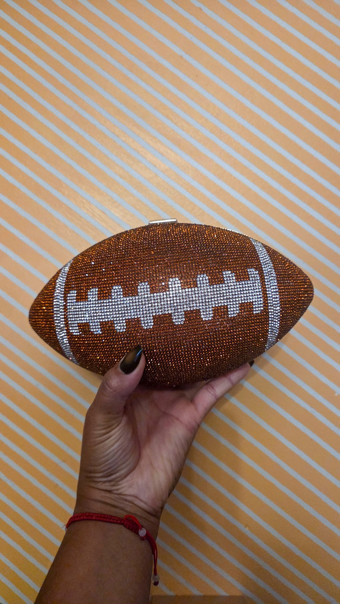 Catch the game in style with this dazzling football clutch! Perfect game day accessory.

