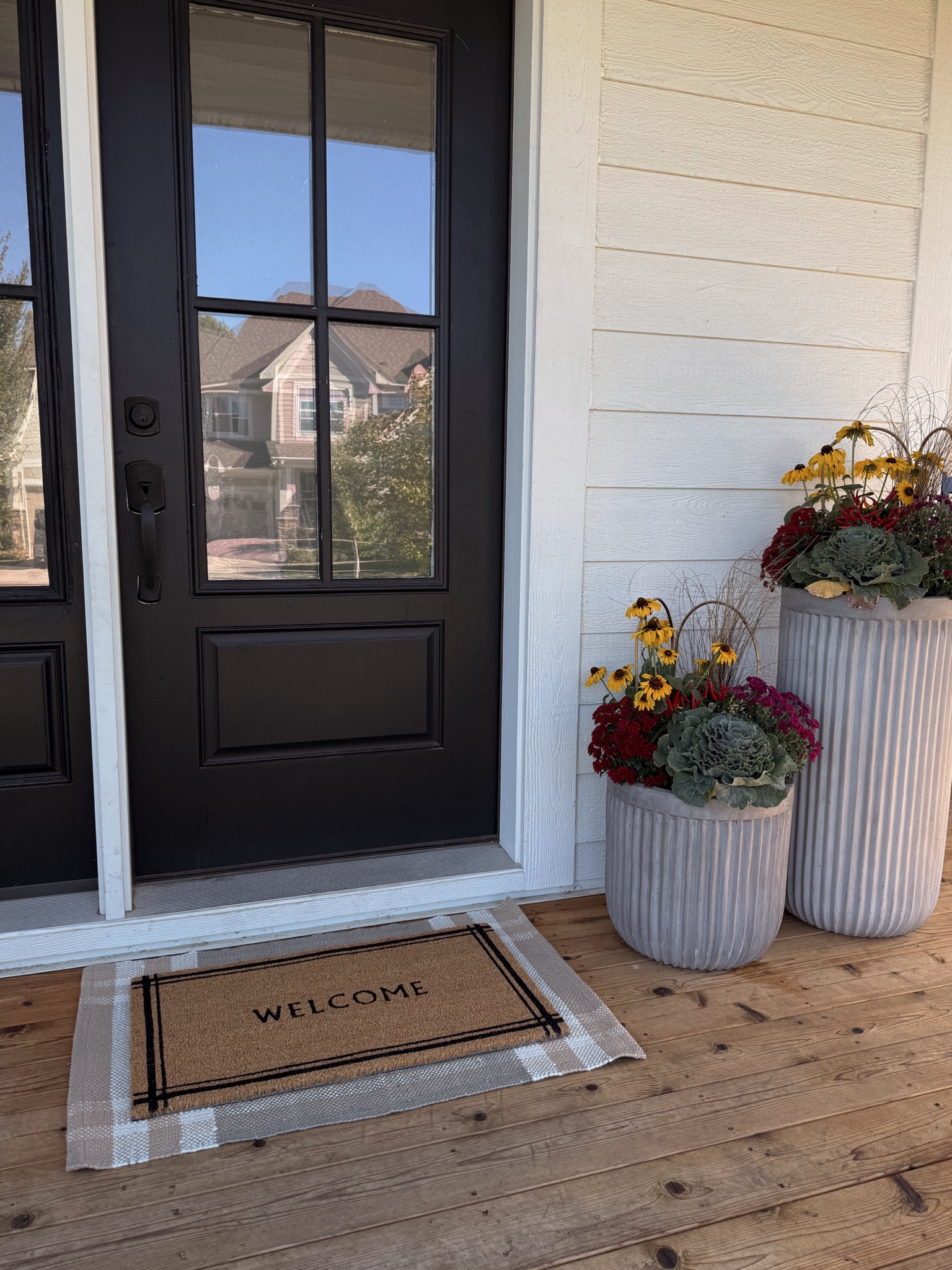 Fall front porch 🍂 

The arrangements are real and from a local nursery, but include mums, cabbage, little peppers and black eyed Susan flowers. 

Door & sidelight from Pease Doors, painted SW tricorn black

Concrete fluted planters on sale! 
Target layered doormat/rug 🤎

#LTKHome #LTKSeasonal #LTKSaleAlert